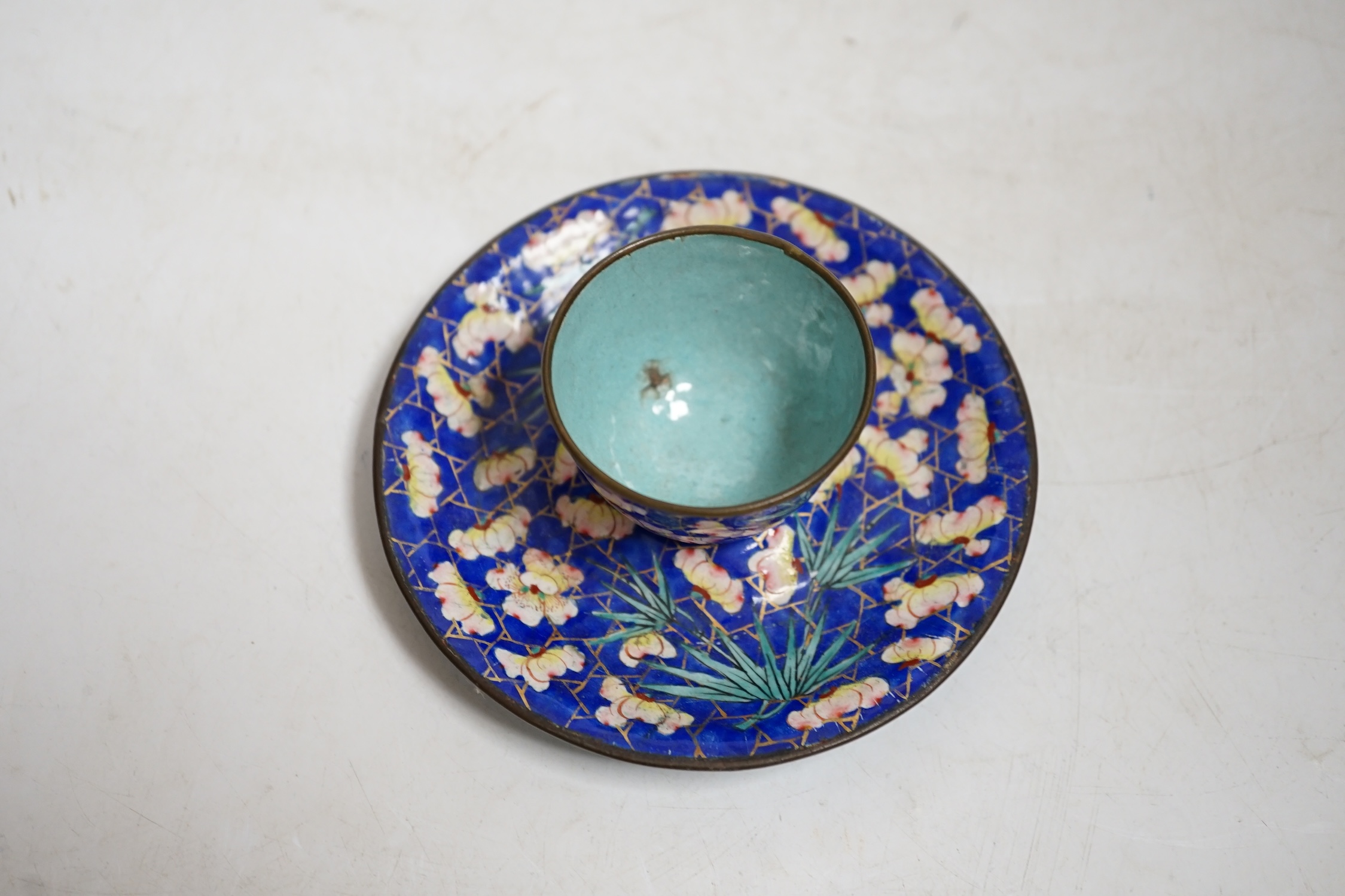 A 19th century Canton enamel tea bowl and stand, 11cm in diameter. Condition - saucer good, cup poor